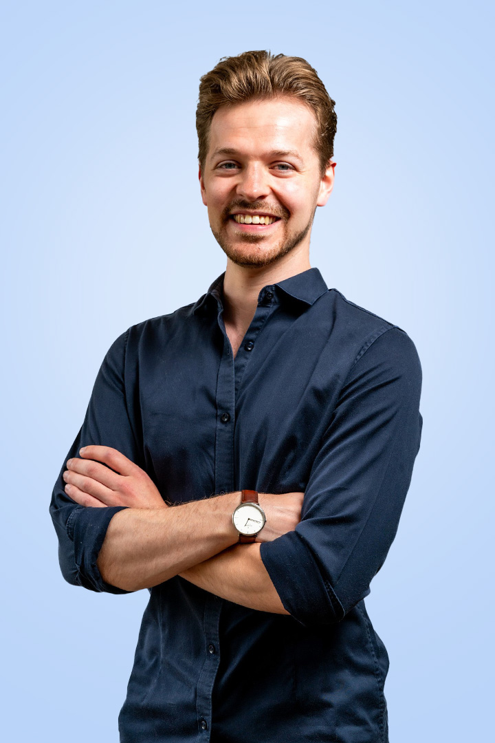 Lachende man met blauwe blouse en horloge
