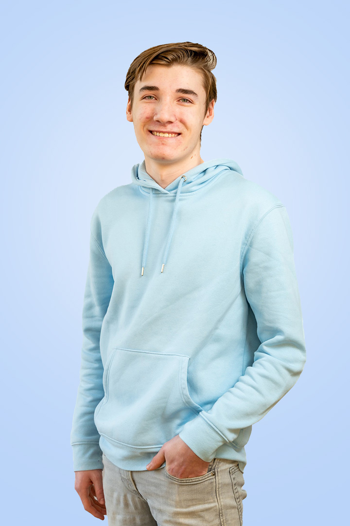 Jongeman in blauwe hoodie glimlacht.