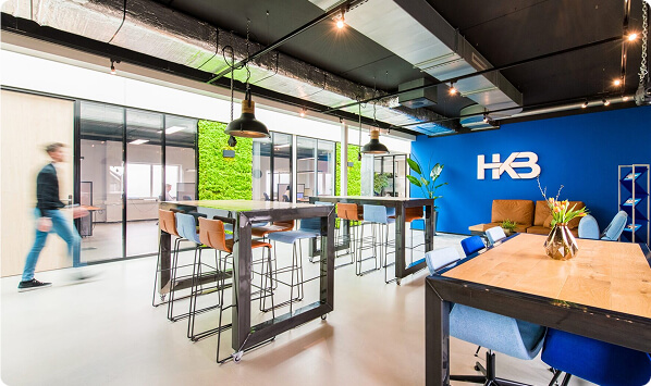 Moderne kantoorruimte met groene wand en HKB-logo.
